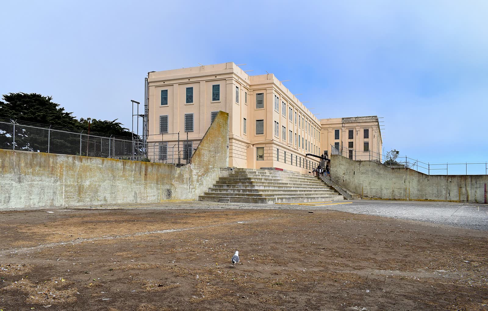 The walled recreation yard of the former Alcatraz prison with the dining hall building behind it
