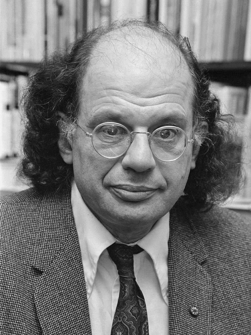 Black and white photograph of the poet Allen Ginsberg signing books at the Athenaeum bookshop in Amsterdam, 1979