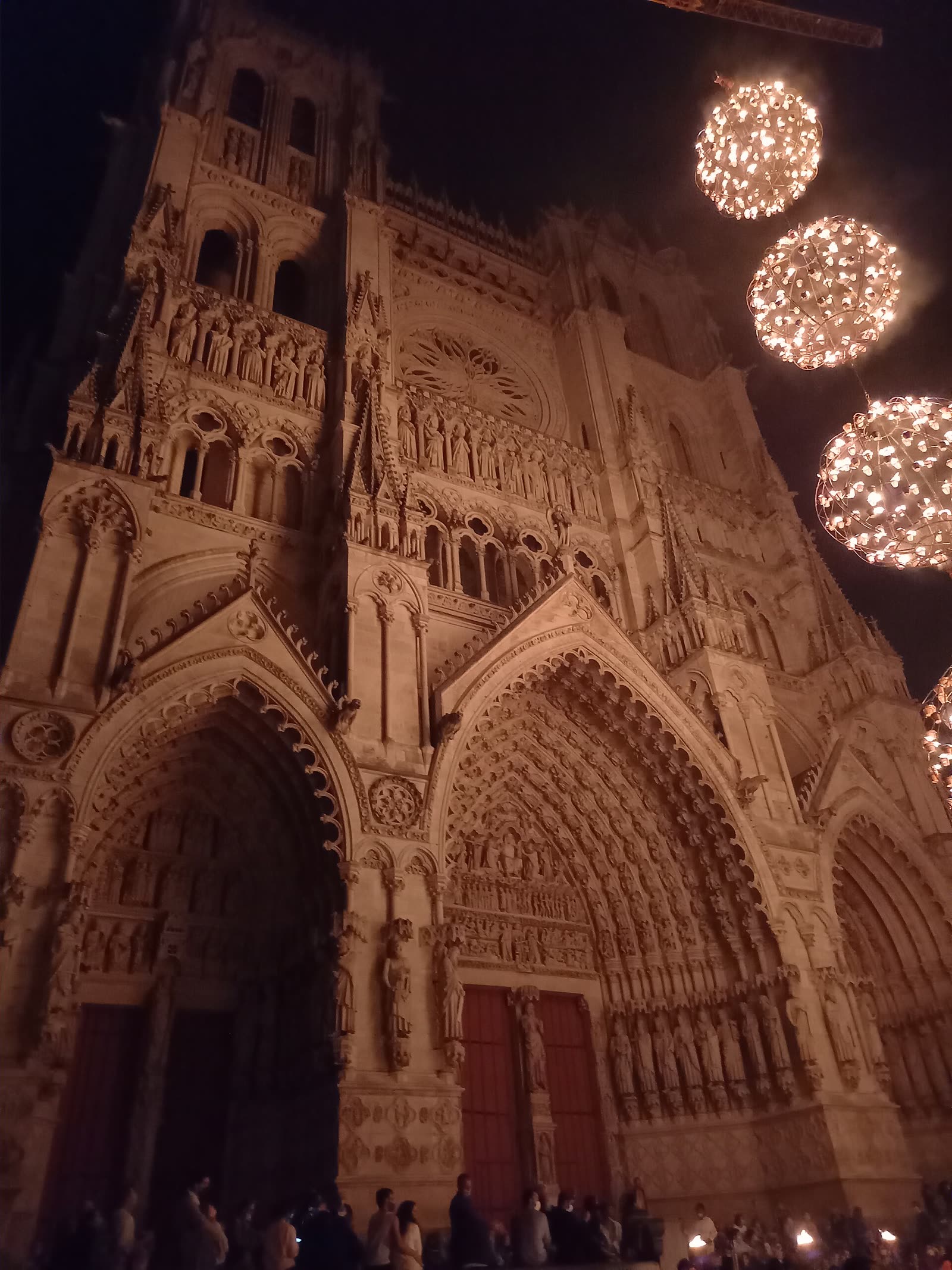 Coloured light projected onto the carved facade of Amiens Cathedral at night, September 2021