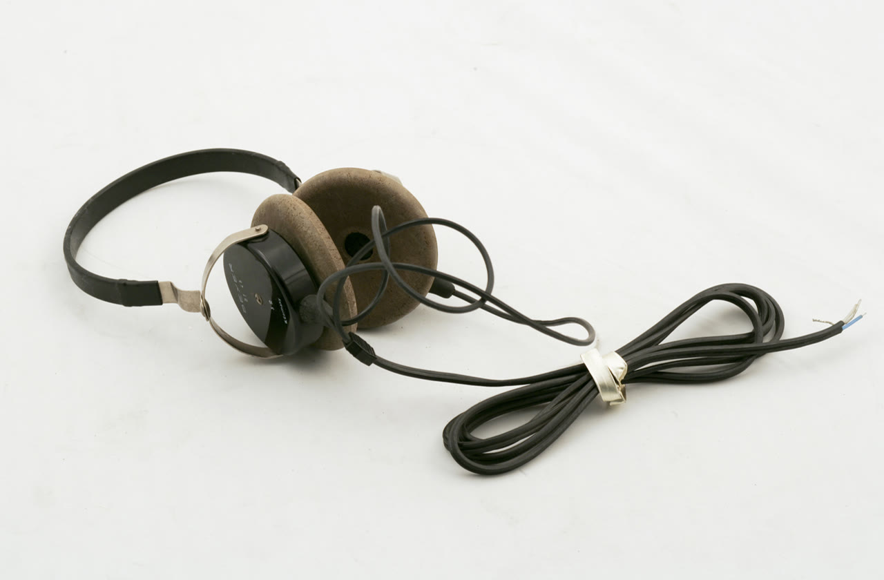 Pair of black and brown Beyer dynamic headphones with a coiled cable on a white background