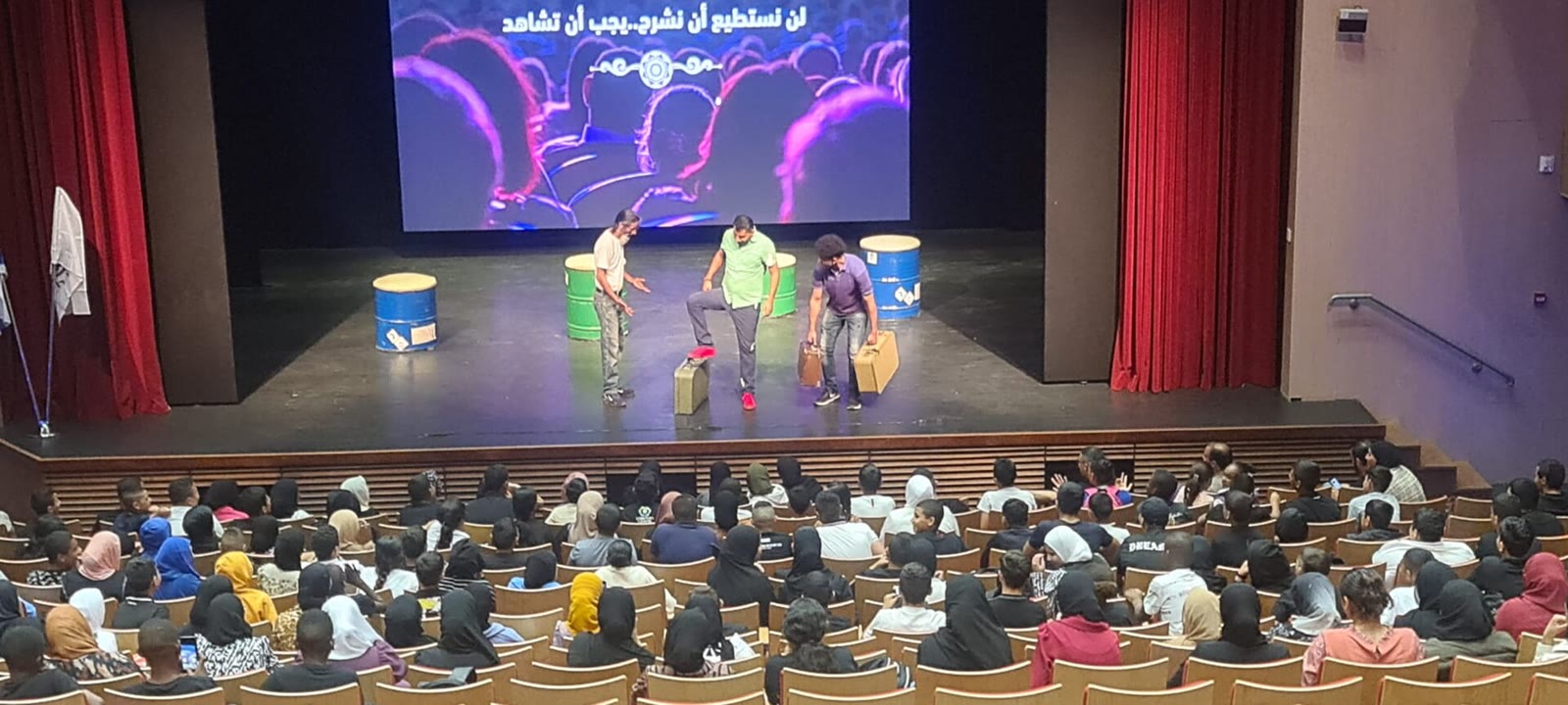 A large crowd of children seated together watching a play by the al-Mihbash theatre in Rahat, Israel