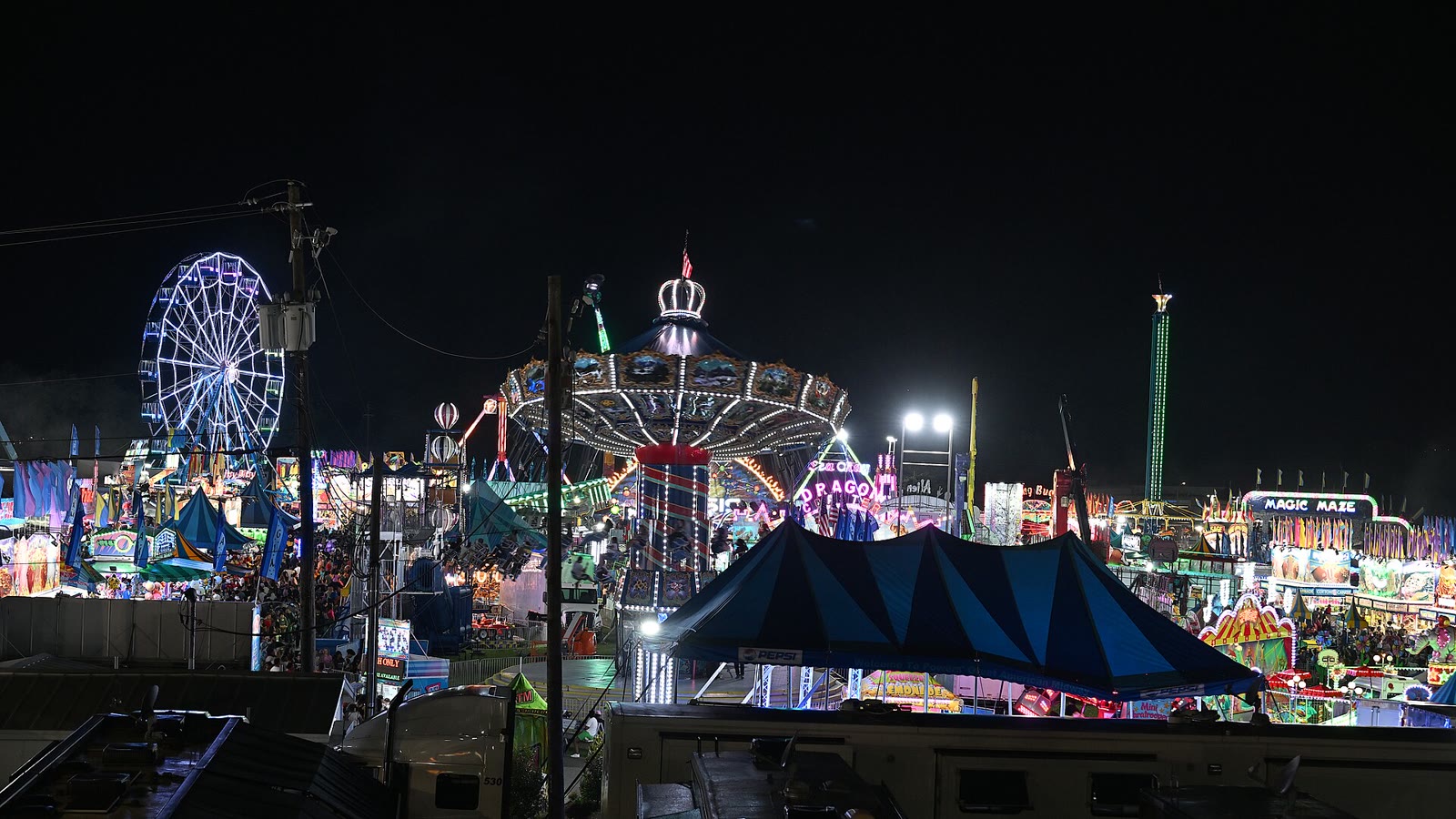 Lit rides and game booths on a county fair midway at night