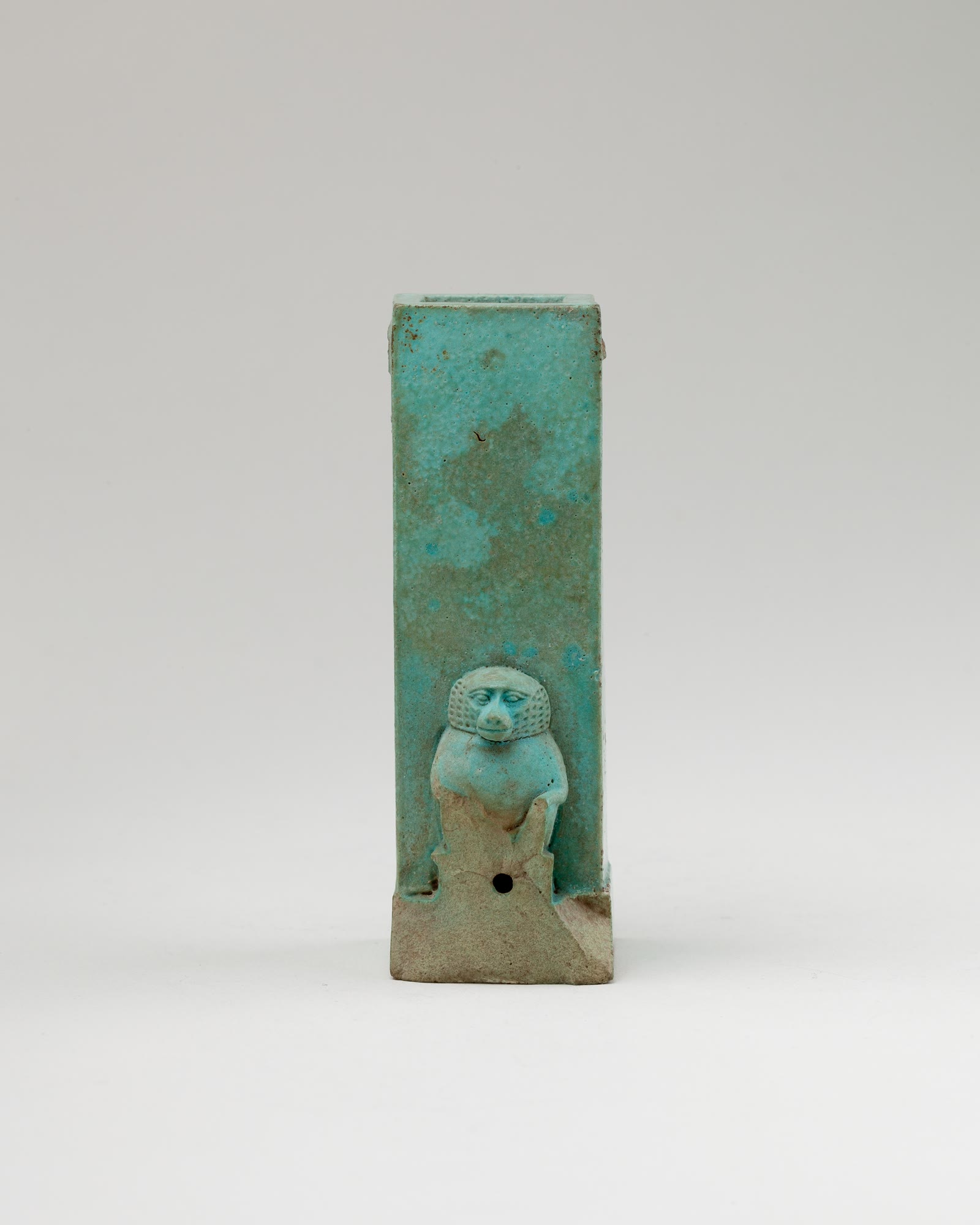An ancient Egyptian water clock model with a squatting baboon figure