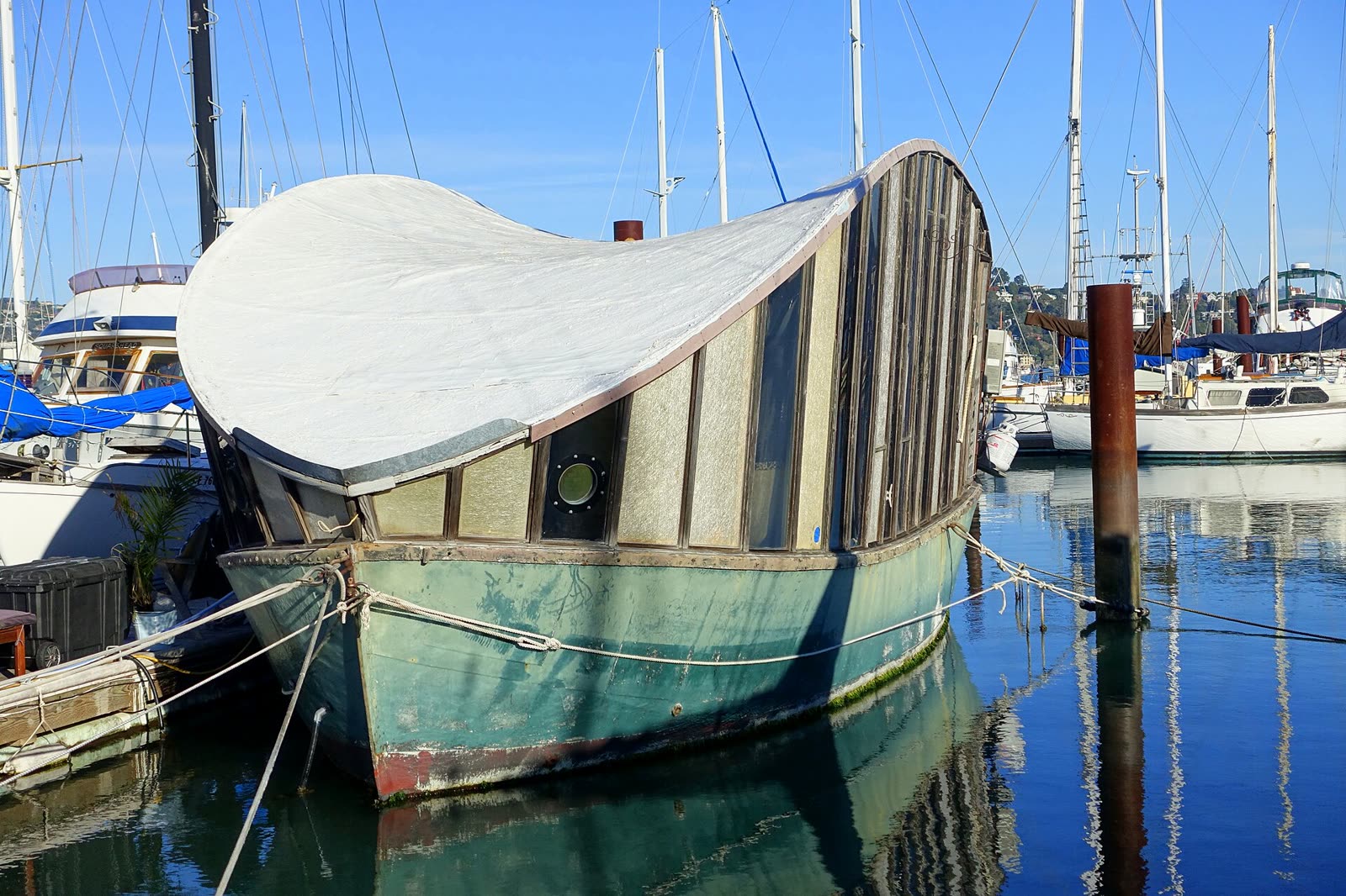 A houseboat moored at a dock in Galilee Harbor on the Sausalito waterfront