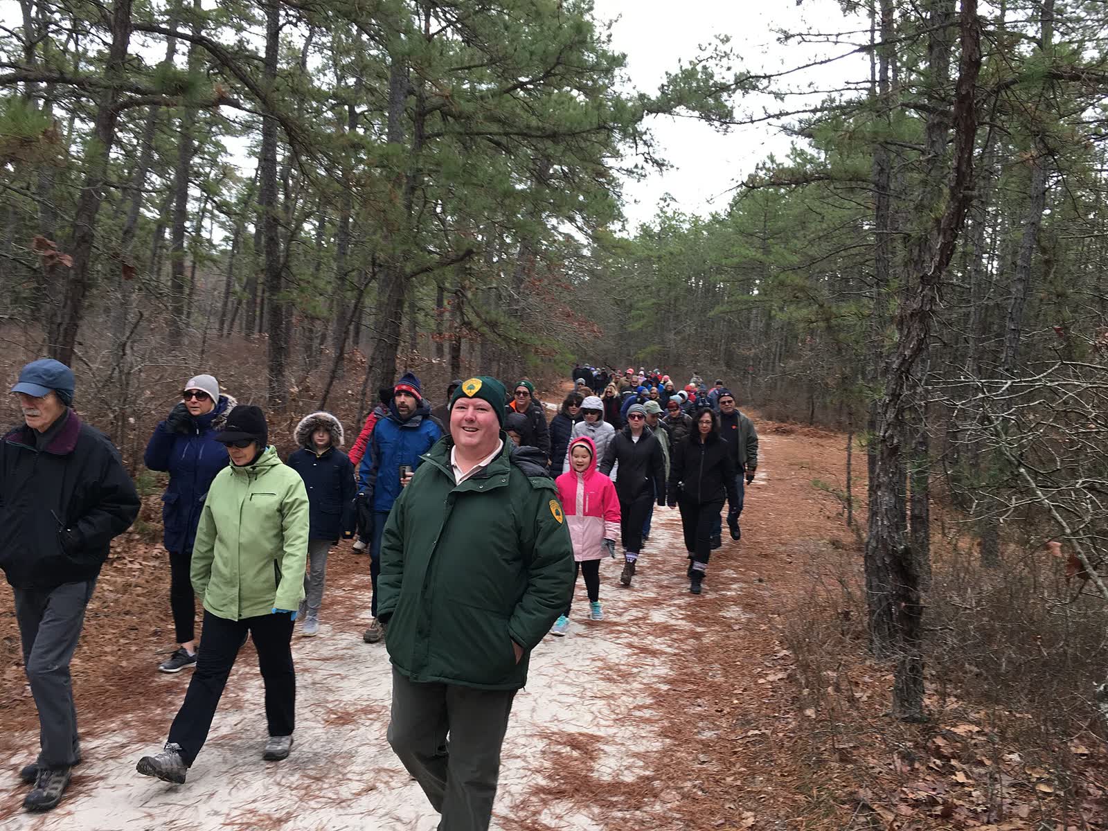 Large group of people walking together along a trail