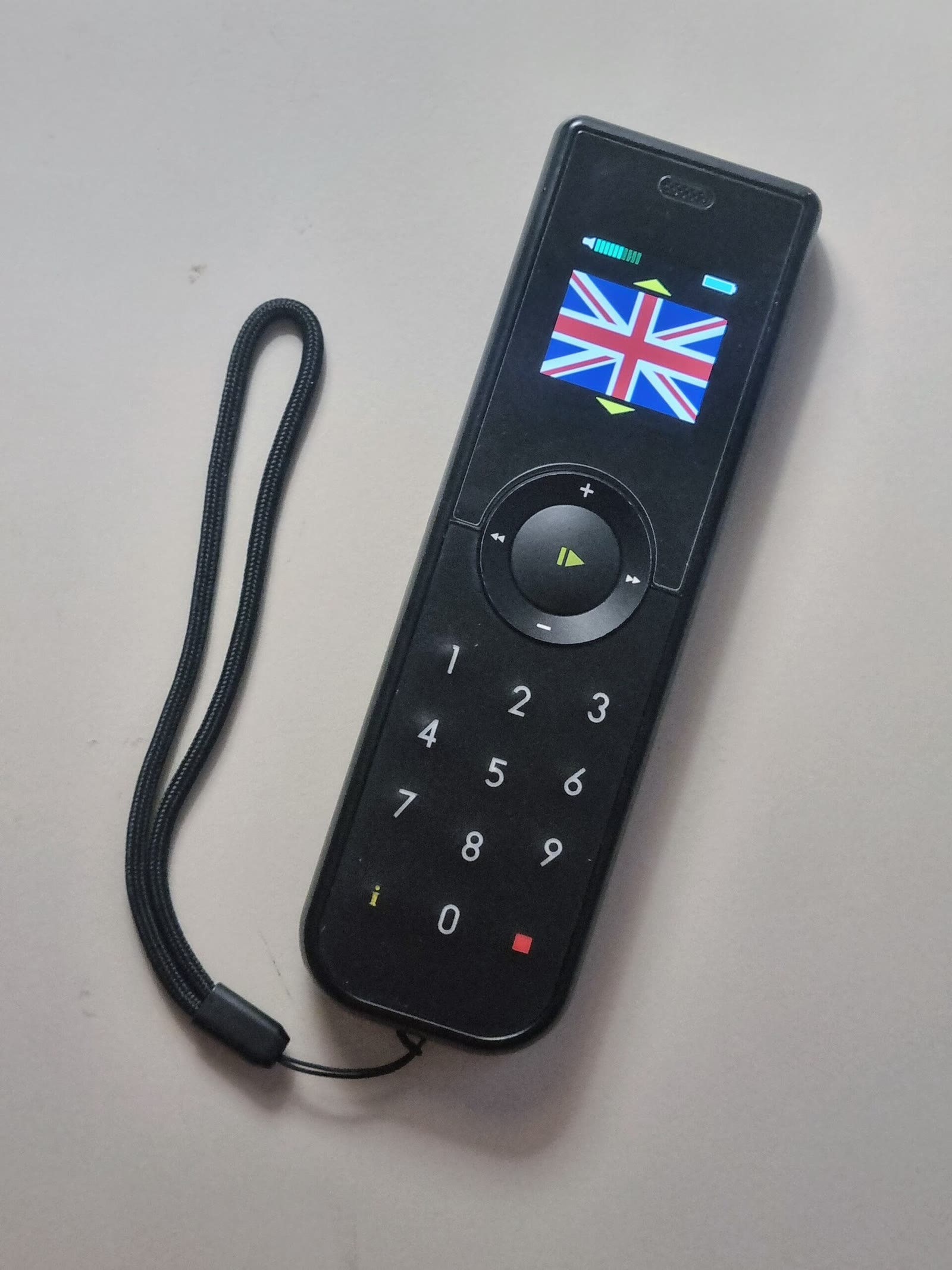 Handheld museum audio guide device with a small display screen lying on a table