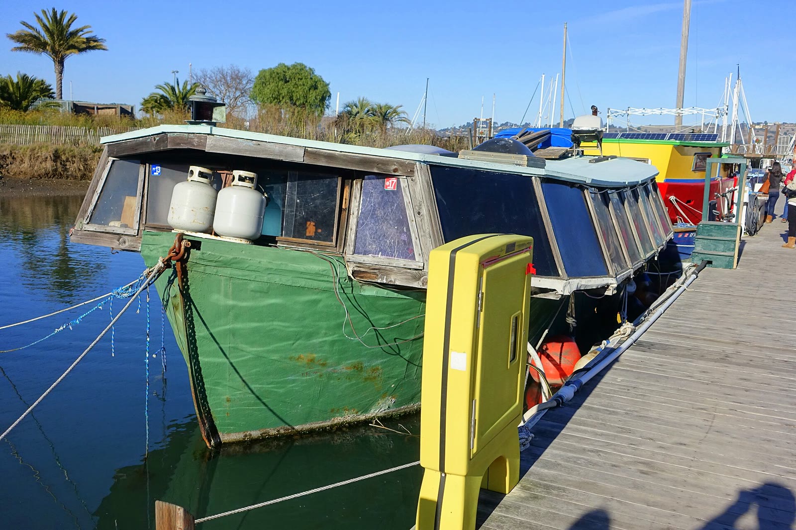A wooden houseboat floating in Galilee Harbor on the Sausalito waterfront