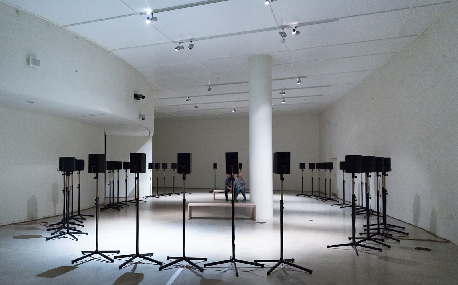 Loudspeakers on stands arranged in an oval in a gallery for Janet Cardiff's The Forty Part Motet