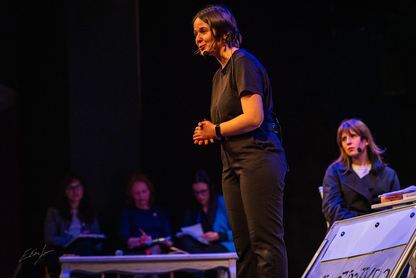 A facilitator, the Joker, addressing the audience from the stage at a Legislative Theatre performance in Sofia