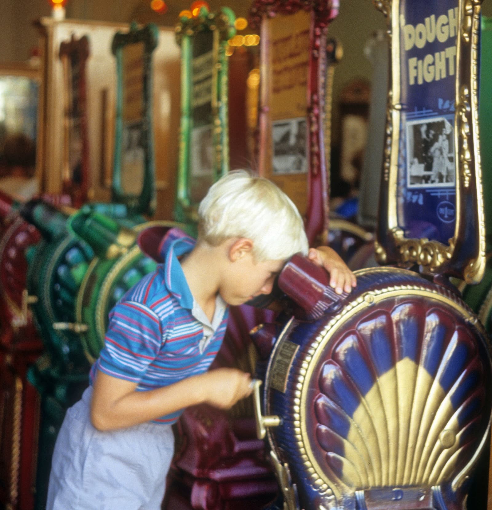 A boy looking into a mutoscope, a coin-operated picture viewer, in a penny arcade in the 1980s