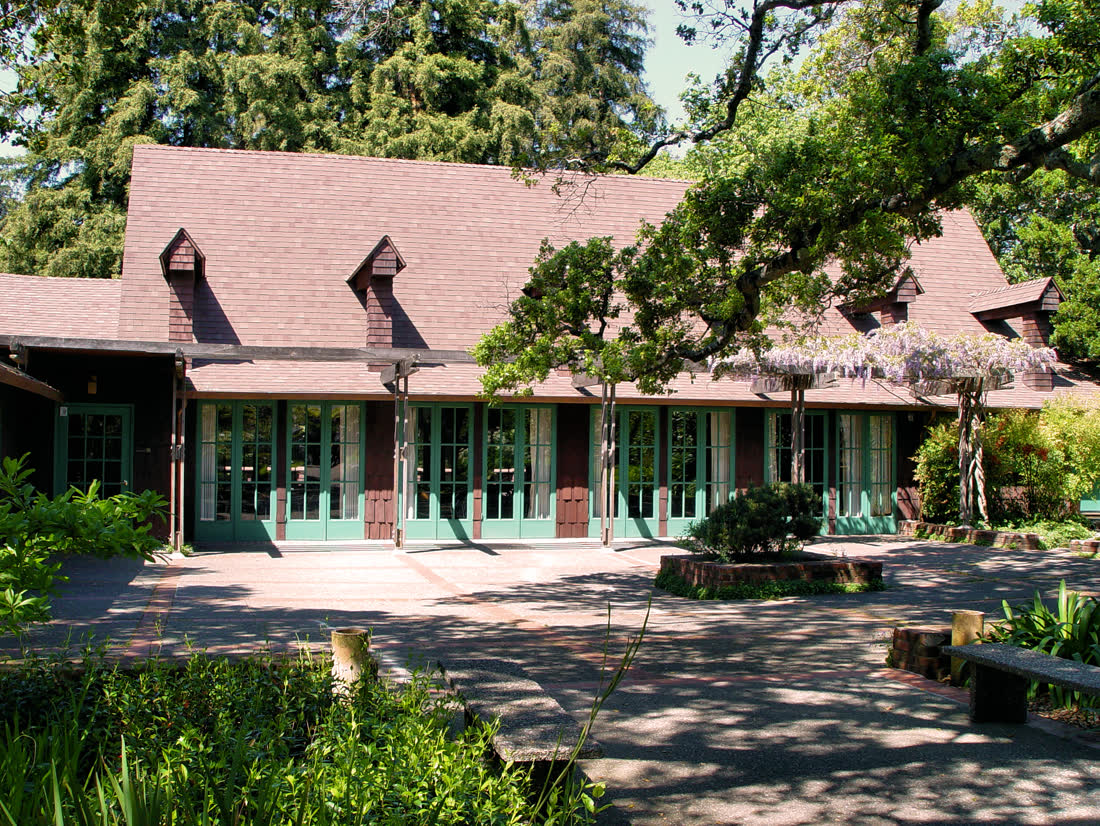 The shingled Outdoor Art Club clubhouse in Mill Valley behind trees and a garden