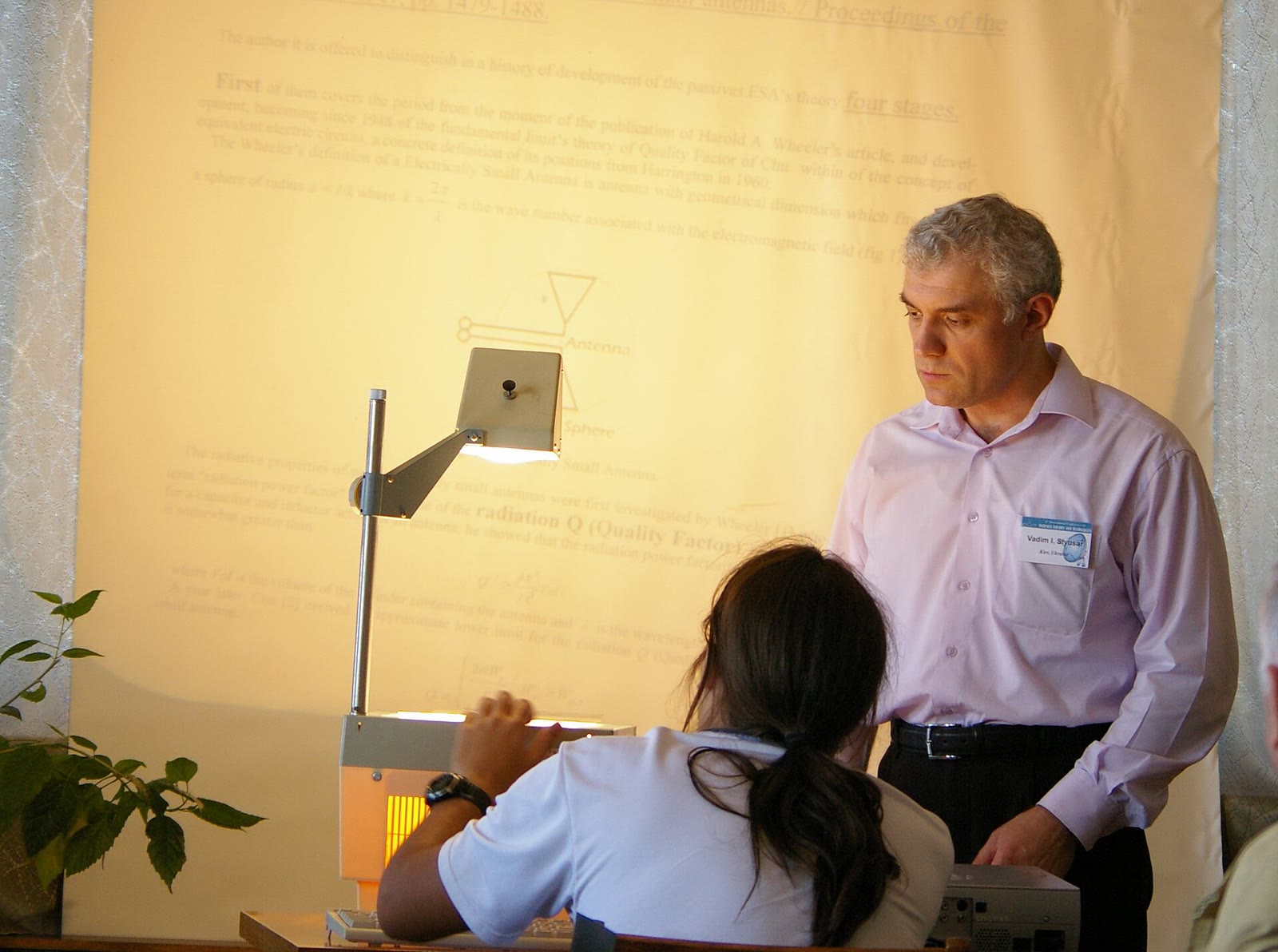 An overhead projector with its glass stage and folding mirror arm set up on a table