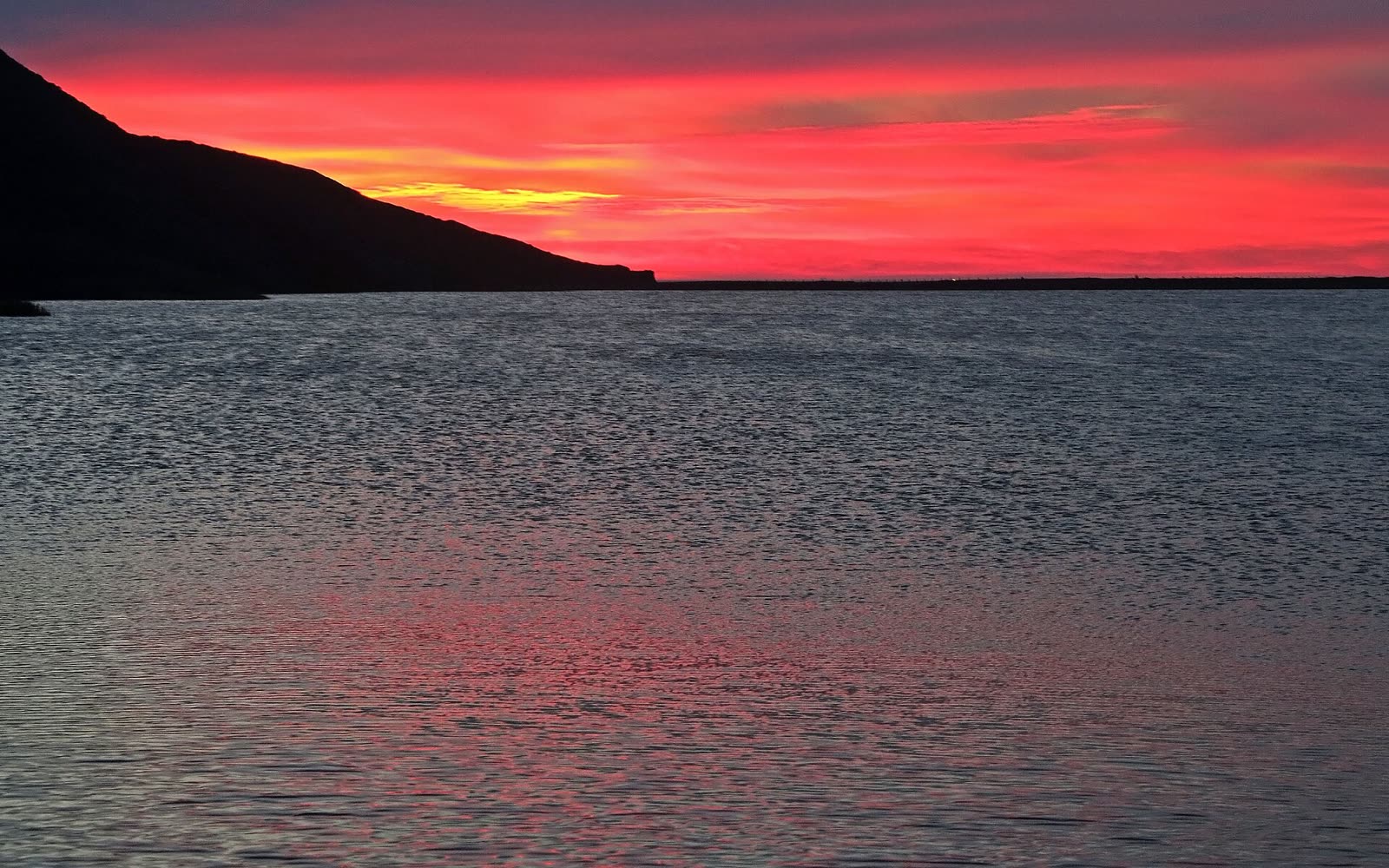 Sunset over Rodeo Lagoon with the sand bar of Rodeo Beach near the horizon in the Marin Headlands