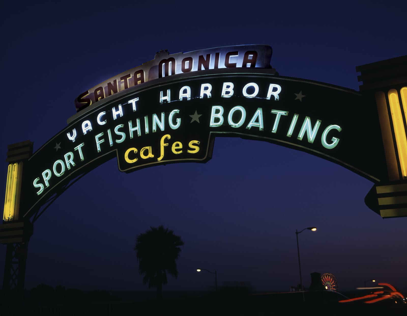 The Santa Monica Pier sign lit up at night