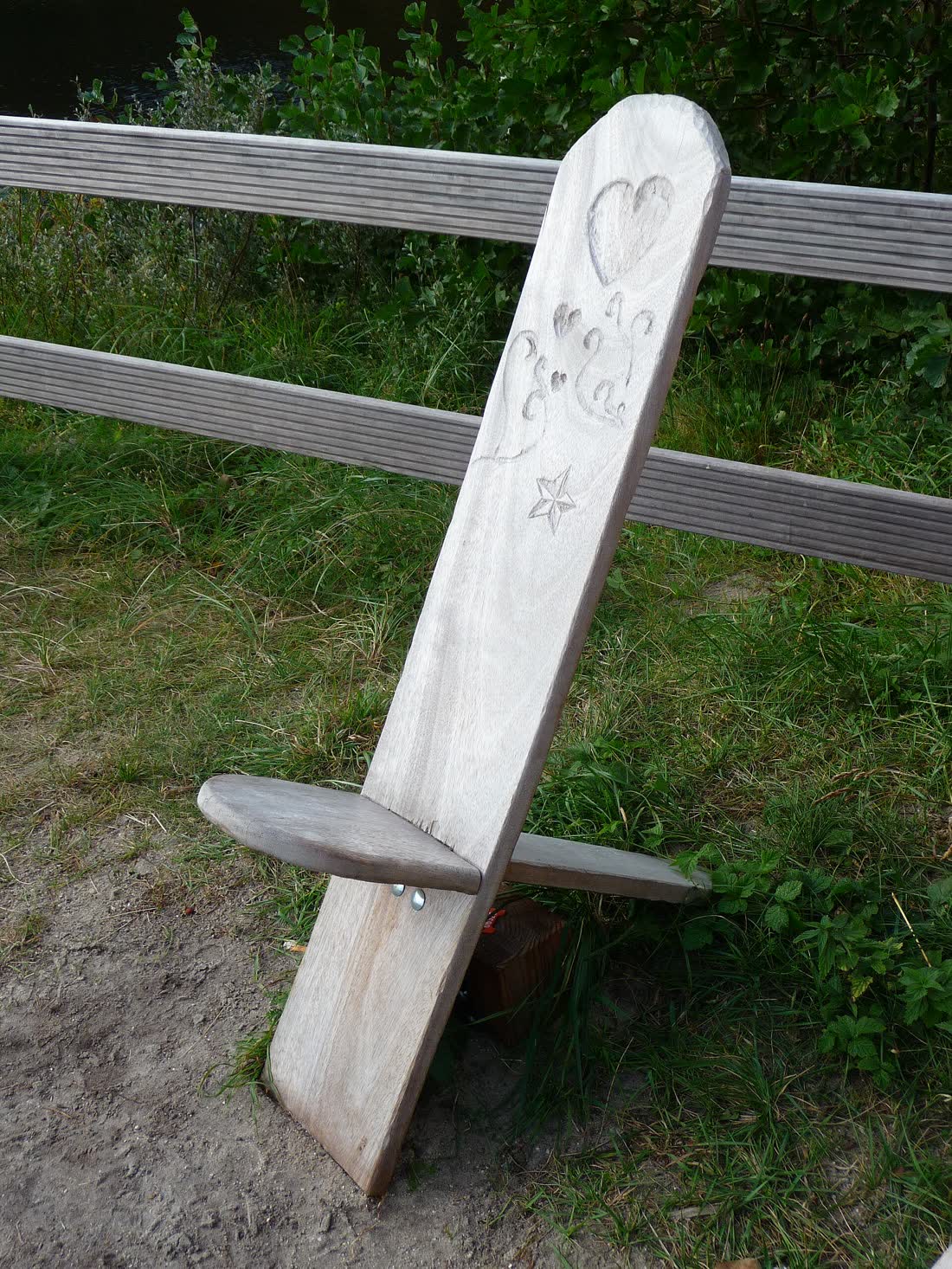 A wooden slot-together chair with a carved backrest, photographed on the island of Juist