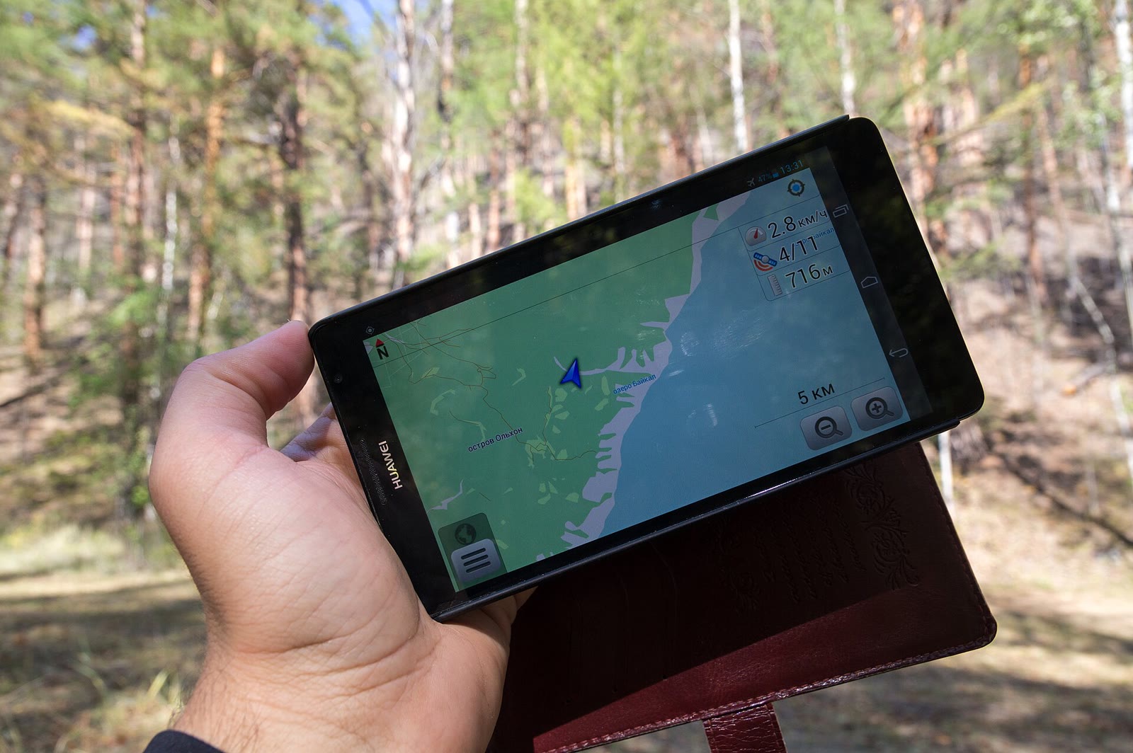 A smartphone showing a GPS navigation map outdoors on Olkhon Island, Lake Baikal