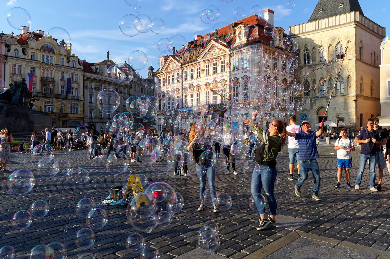 Large soap bubbles floating in the air over a city square