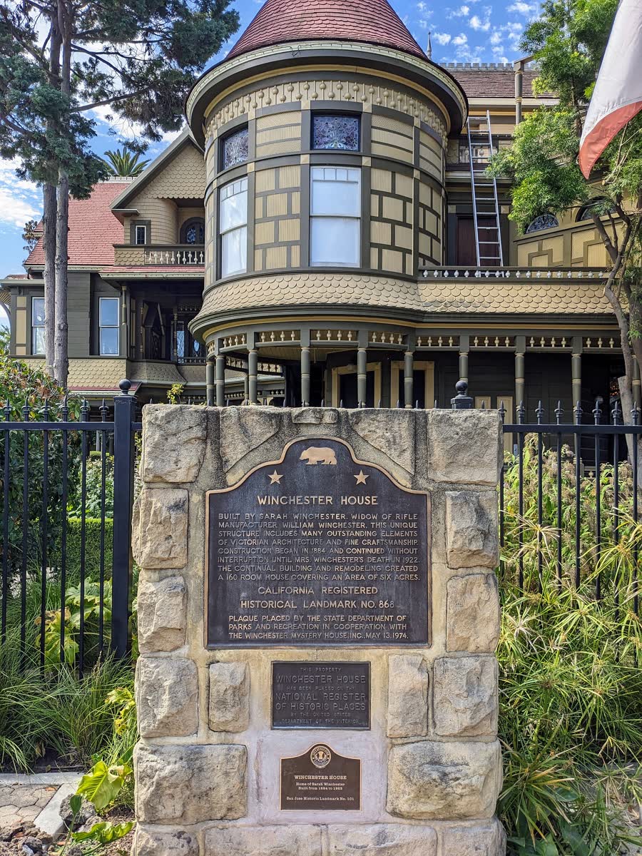 Bronze state landmark plaque set in a stone pillar in front of the Winchester house turret