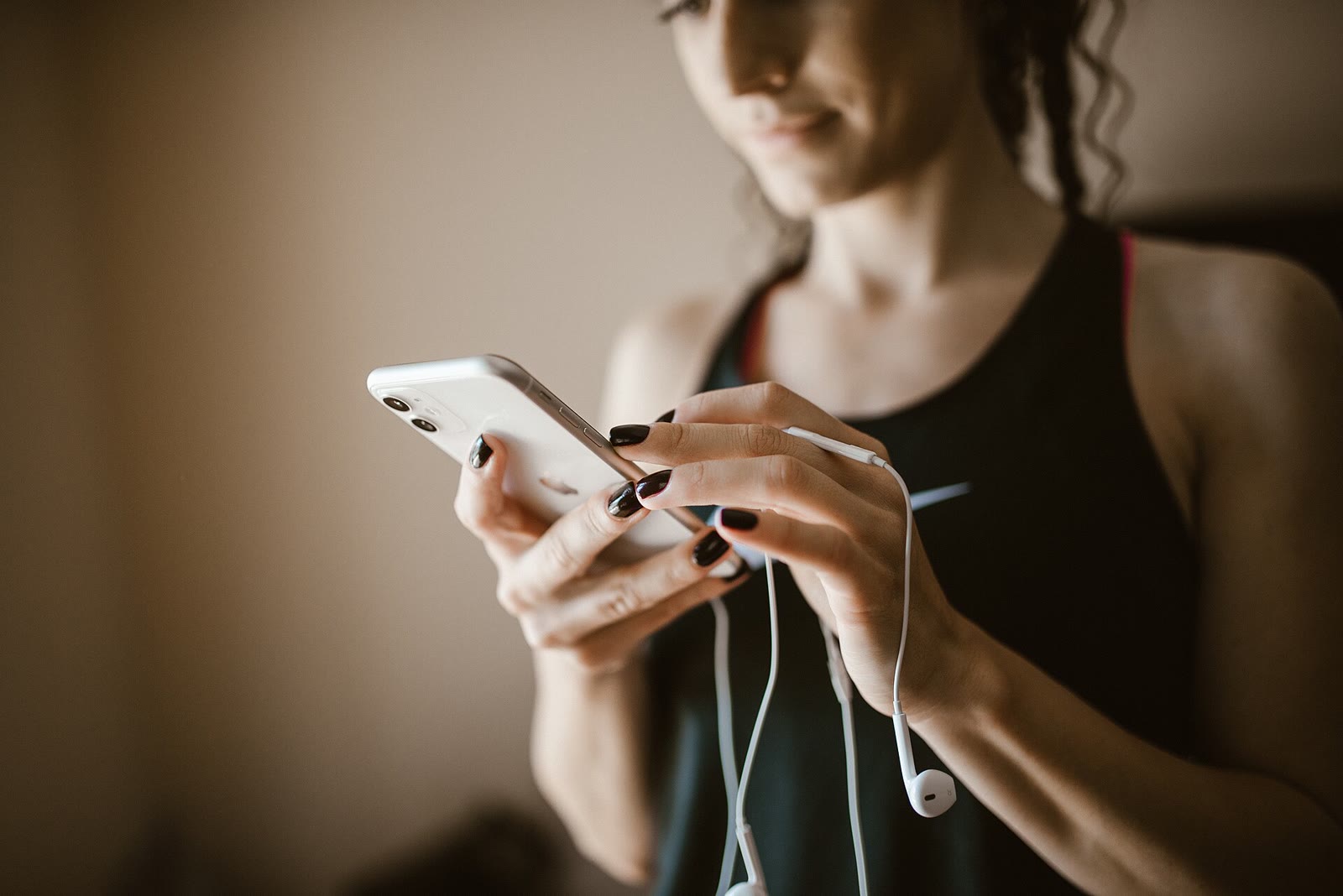 Young woman wearing earbuds looking at her smartphone