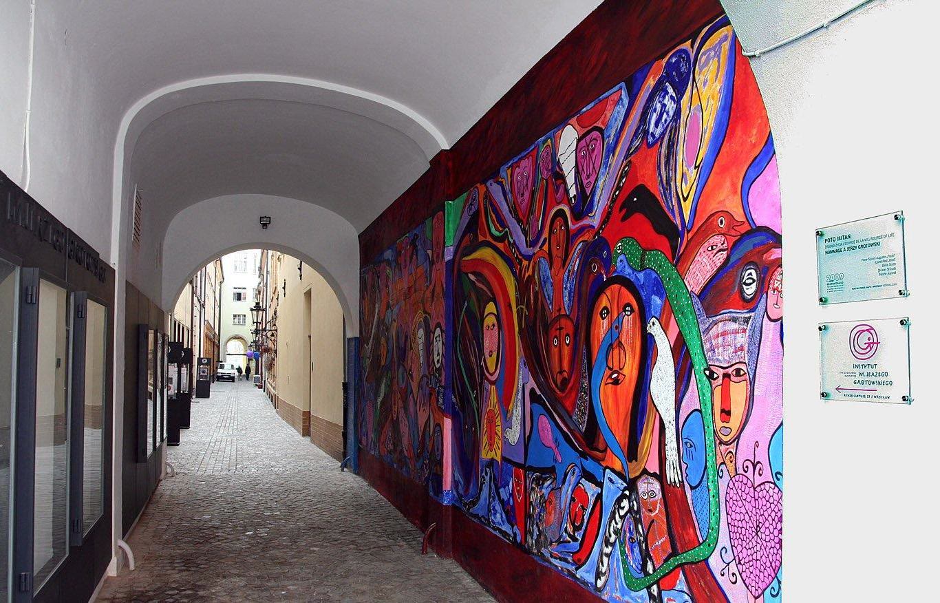 The entrance to a passage off the east side of Wrocław's market square, with a mural dedicated to Jerzy Grotowski on the right